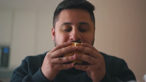 Man Taking Delicious Bite of Burger Close-Up