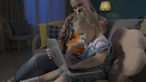 Woman and Child Using Laptop Together on Sofa