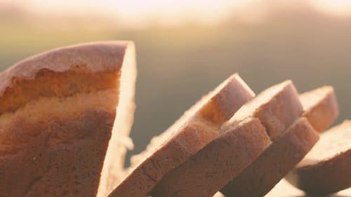 Slow Pan Across Freshly Baked Homemade White Bread with Slices on Wooden Chopping Board Outside.