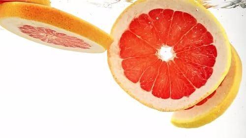 Refreshing Grapefruit Slices Falling Into Water