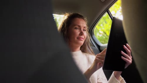 Transport, Vehicle and Technology Concept - Happy Smiling Woman in Car Using