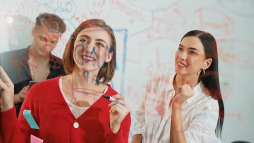 Team Brainstorming on Glass Whiteboard in Office Workplace