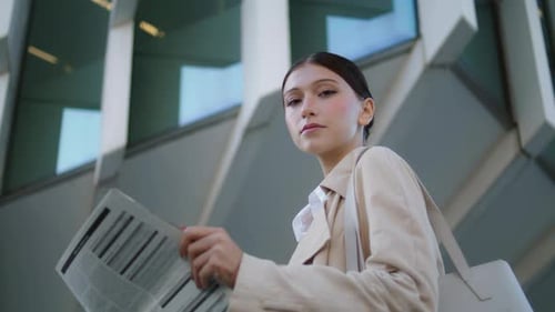 Business Woman Holding Newspaper Standing in Front Modern Building Close Up