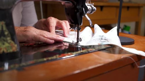 Close up shot of unrecognisable elderly woman working on an old vintage sewing at home