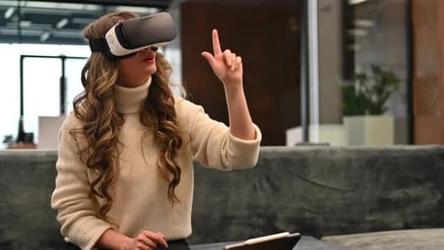 Happy woman working with VR virtual reality set on head at the office