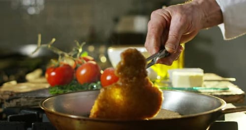 Chef Cooking Cutlet in Silver Frying Pan