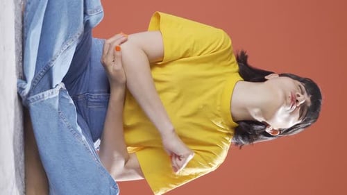 Woman Massaging Sore Arm in Studio Setting