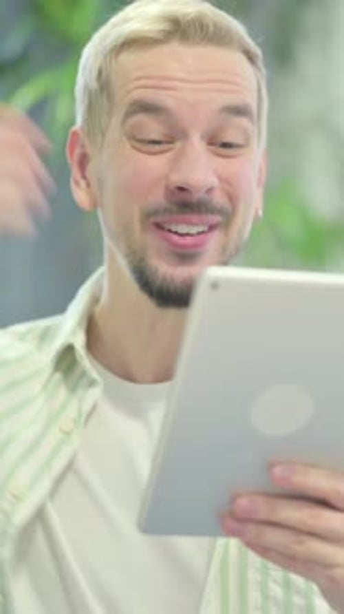 Excited Man With Tablet Celebrates Success in Office