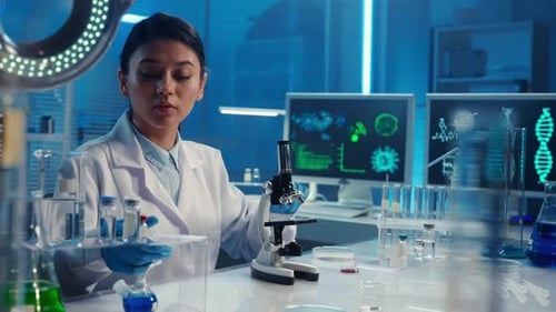 A Korean Female Doctor Applies a Sample of Red Liquid with a Pipette and Examines It Under a