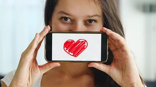 Woman Holding Phone Displaying Hand-Drawn Red Heart