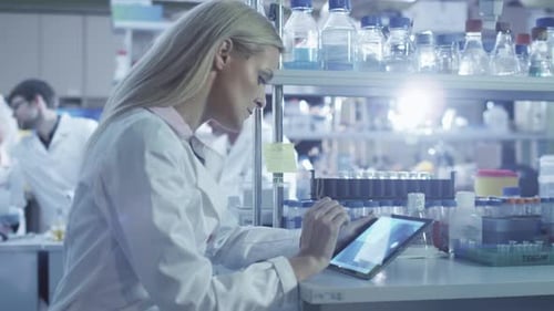 Female scientist is using a tablet while working in a laboratory.