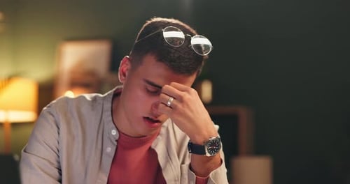 Stress, student and man in home at night with anxiety for university exams, studying and learning