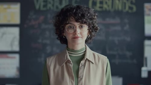 Portrait of Young Female Student against Blackboard in College Classroom