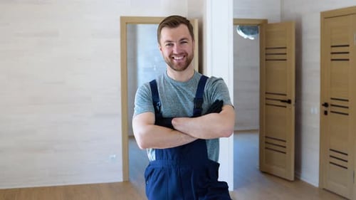 Smiling Man Poses Indoors with Arms Crossed