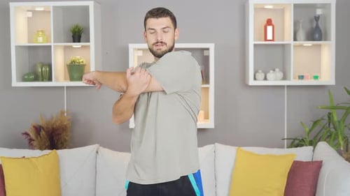 Young Man Stretching Arms at Home