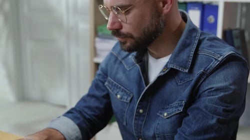 Man Typing on Laptop at Desk in Office Setting