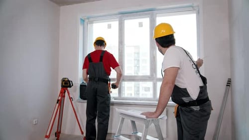 Wohnungsreparatur Ein Arbeiter misst das Fenster in der