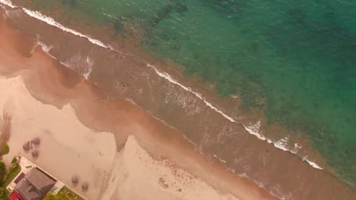 AERIAL: Waves breaking on the beach.