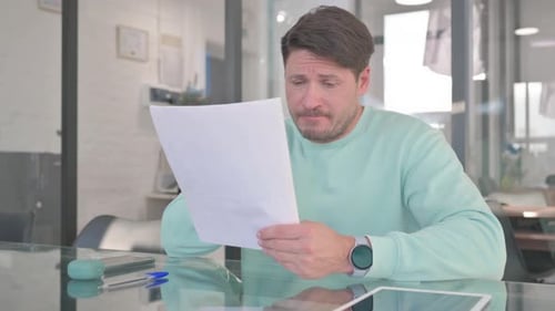 Man Reads Documents at the Office Desk