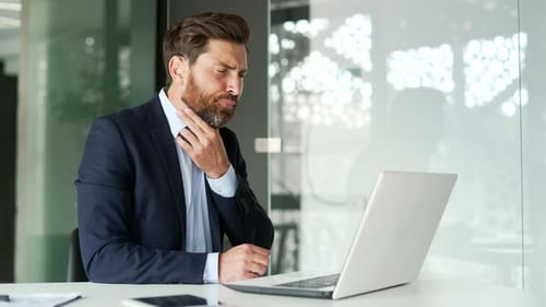 Man in Suit Experiencing Throat Pain at Desk