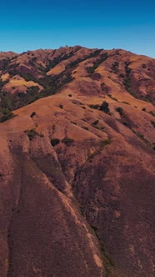 Rising above mountains, bare brown rocks with no vegetation, rock with moss.
