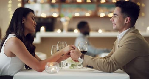 Smiling Couple Holding Hands During Romantic Dinner
