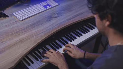 caucasian musician playing piano in his home studio