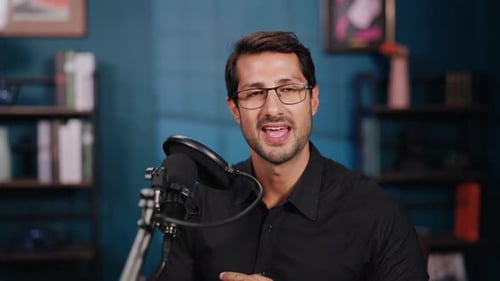 Portrait of Happy Man Wearing Glasses Talks at Podcast in Audio Recording Studio