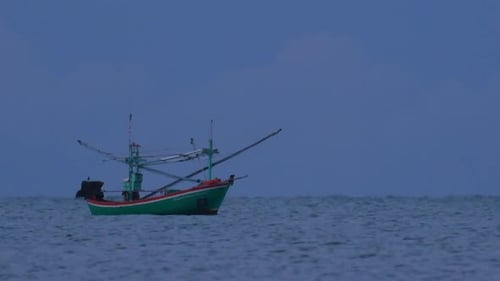 Fishing Boats in Thailand wait in the middle of the ocean for dark to come so they can turn on their