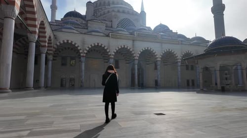 Frau in Zeitlupe geht durch den Innenhof der Istanbuler Moschee
