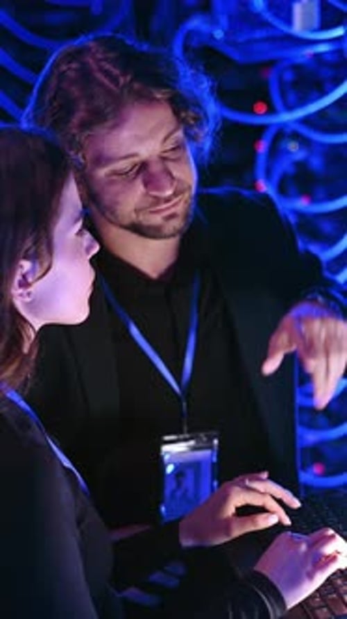 Technical workers in a data center at night