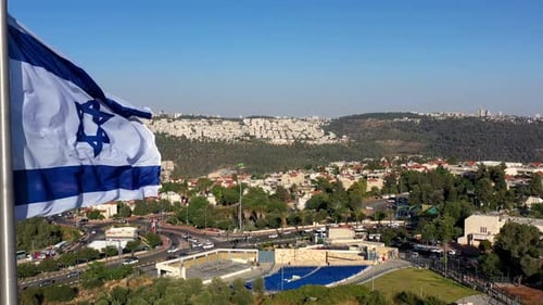 Waving Israeli Flag Overlooking Cityscape