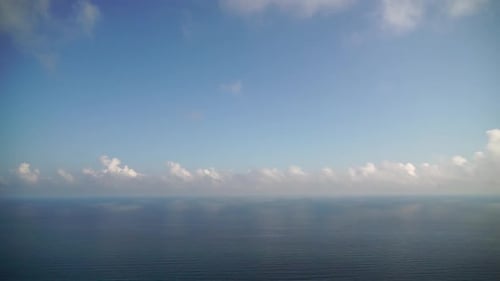 Zeitraffer flauschiger Wolken, die sich am blauen Himmel über dem ruhigen Meer bewegen, abstrakte Luft, Natur, Sommer, Ozean