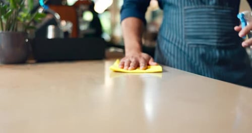 Hands, cafe and person cleaning table with spray, cloth or chemical disinfection for hygiene