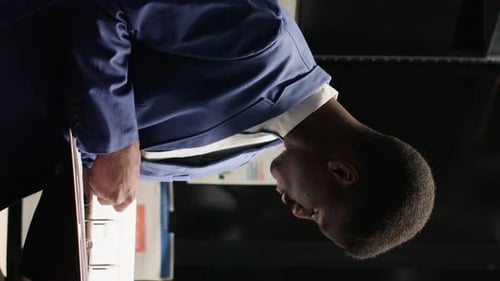 Smiling Man in Suit Looking at Documents