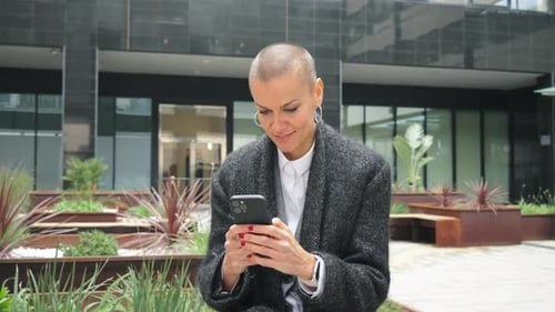 Stylish Woman Using Smartphone in Urban Setting