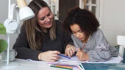 Woman Helping Child With Homework At Home