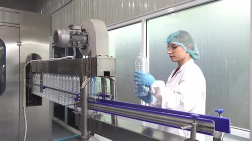 Inspektor überprüft Flaschen in der Brauerei. Mitarbeiter der Wasserfabrik, der Qualität und Inspektion überprüft