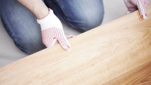Repair, Building, Floor and People Concept - Close Up of Man Installing