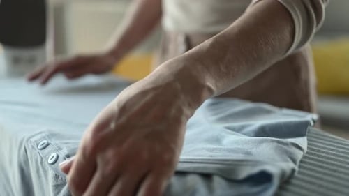 Girl Hand Using Iron for Wrinkled Clothes