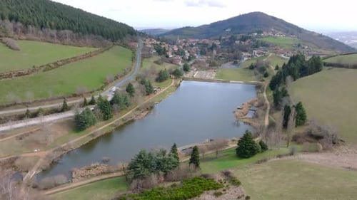 Aerial shot of a landscape with lake and mountains and a village