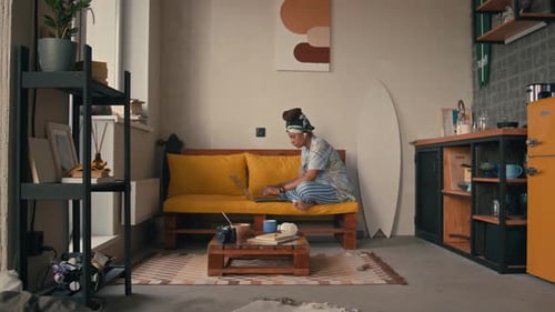 Young Female Freelancer Working on Laptop Computer in Loft Apartment