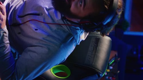 Gamer with Headphones Relaxing in Gaming Chair