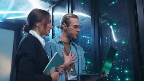 A Man and Woman Analyze Data Together in a Hightech Server Room