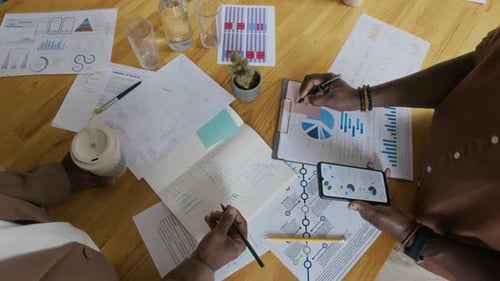 Unbekannte afroamerikanische Geschäftsleute arbeiten gemeinsam am Tisch an einem Projekt