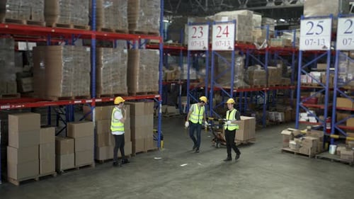 Blue collar workers are working at warehouse.