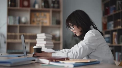 Focused asian student working on laptop in a university library