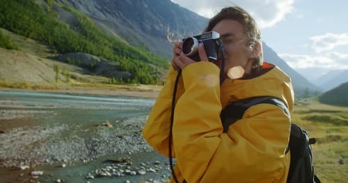 Woman Taking Pictures with Vintage Camera in Mountains
