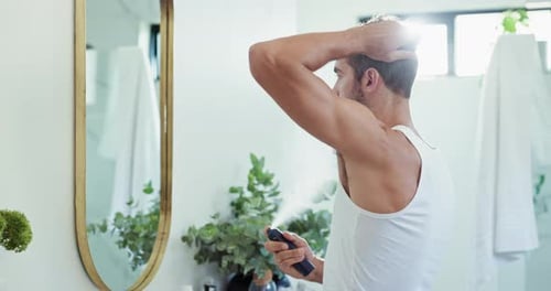 Man Styling Hair in Brightly Lit Bathroom