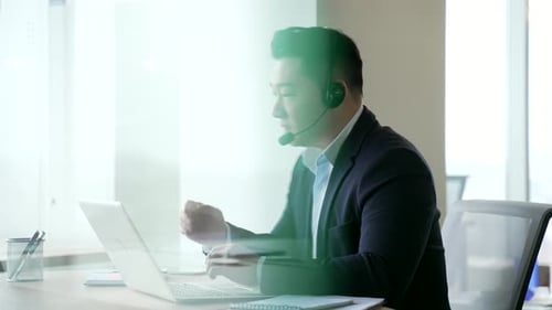 Young Adult with Headset Working at Laptop